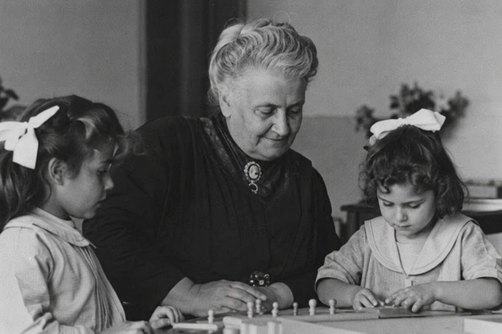 María Montessori con dos niñas