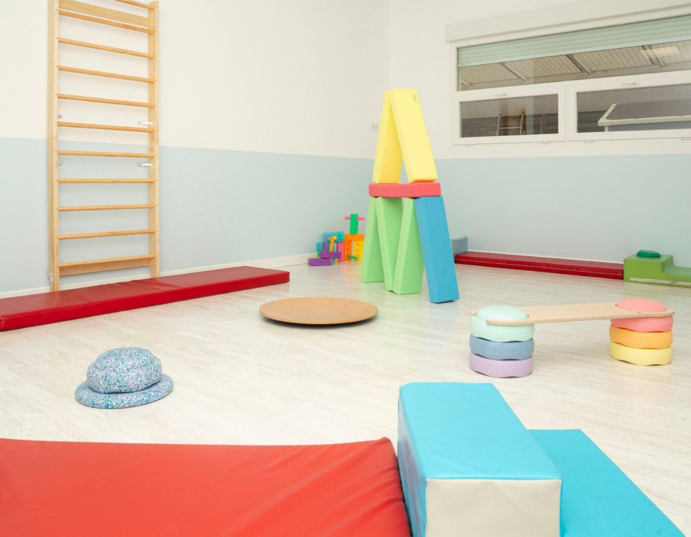 Sala de juegos colorida Sala de juegos colorida con colchonetas, bloques apilables y equipo de ejercicio.